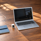 Small VibeTV with the Pixel Battery theme showing Claude usage beside a full-size laptop on a daylight desk