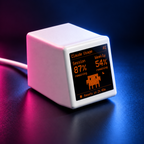 Close-up of VibeTV with the Claude theme in pink and blue desk lighting